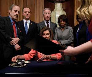 La presidenta de la Cámara de Representantes Nancy Pelosi (D-CA) (C) recibe un documento mientras firma los artículos de juicio político del presidente de los Estados Unidos, Donald Trump, durante una ceremonia de absorción en Capitol Hill el 15 de enero , 2020, en Washington, DC. La Cámara de Representantes de los Estados Unidos votó el miércoles para transmitir al Senado artículos de juicio político contra el presidente Donald Trump, abriendo el camino para el juicio histórico del 45 ° presidente por abuso de poder. / AFP / Brendan Smialowski