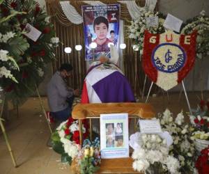 Un hombre se arrodilla junto al ataúd de Jack Bryan Pintado Sánchez, un joven de 22 años que murió durante las protestas del fin de semana contra la destitución del presidente Martín Vizcarra por parte de los legisladores, en una iglesia durante su velatorio en Lima, Perú, el lunes 16 de noviembre de 2020. Foto: AFP