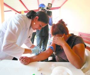 Esta doctora saca una muestra sanguínea de una paciente con sospecha de virus de chikungunya.