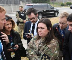La secretaria de prensa de la Casa Blanca, Sarah Huckabee Sanders, habla con reporteros después de que helicópteros presidenciales devolvieran al presidente estadounidense Donald Trump al ejército estadounidense Garrison Yongsan en Seúl, Corea del Sur el 8 de noviembre de 2017, debido al mal tiempo antes de llegar a la zona desmilitarizada ( DMZ). / AFP / JIM WATSON