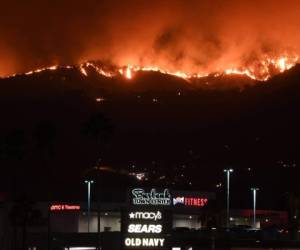 Las enormes llamas envuelven un cerro completo de los suburbios en la ciudad de Los Ángeles. Foto Agencia AFP.