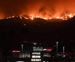 Las enormes llamas envuelven un cerro completo de los suburbios en la ciudad de Los Ángeles. Foto Agencia AFP.