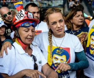 The wife of imprisoned opposition leader Leopoldo Lopez, Lilian Tintori (R), joins thousands of opposition activists protesting against the government of President Nicolas Maduro along the Francisco Fajardo highway in Caracas on June 19, 2017.Near-daily protests against President Nicolas Maduro began on April 1, with demonstrators demanding his removal and the holding of new elections. The demonstrations have often turned violent with 72 people killed and more than 1,000 injured so far, prosecutors say, and more than 3,000 arrested, according to the NGO Forum Penal. / AFP PHOTO / Federico PARRA