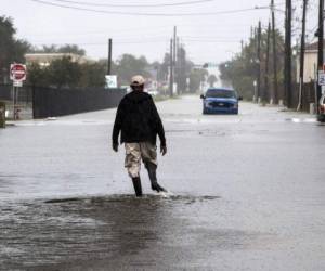 Un hombre camina por una calle inundada en Galveston, Texas, el lunes 21 de septiembre de 2020 mientras se acerca la tormenta tropical Beta. (Brett Coomer/Houston Chronicle vía AP)