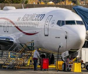 Un trabajador se para debajo de un avión Boeing 737 Max mientras está estacionado en las instalaciones de producción de Renton de la compañía el 13 de noviembre de 2020 en Renton, Washington, Estados Unidos. Foto: AFP