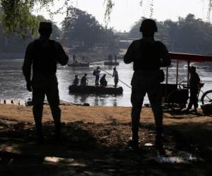 La Guardia Nacional mexicana vigila el río Suchiate en donde locales transportan a personas y mercancía entre México y Guatemala, cerca de Ciudad Hidalgo, México, el viernes 24 de enero de 2020. (AP Foto/Marco Ugarte)