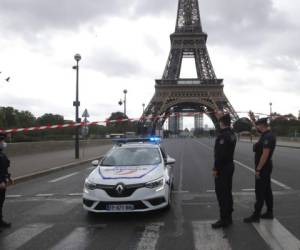 Agentes de la policía francesa aseguran el puente que conduce a la Torre Eiffel, el miércoles 23 de septiembre de 2020 en París. La policía de París ha bloqueado el área alrededor de la Torre Eiffel después de una amenaza de bomba telefónica. Foto: AFP