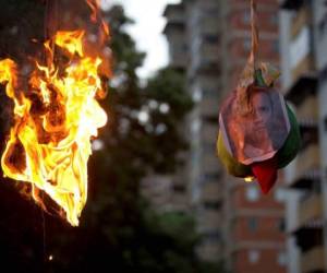 Los miembros de la oposición queman efigies con la imagen del vicepresidente venezolano Tareck El Aissami, en representación de Judas, durante una protesta en Caracas, Venezuela.