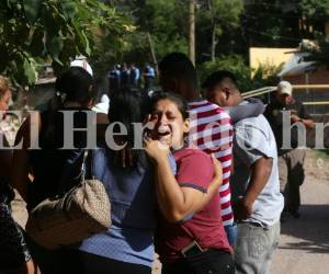 Familiares de Kenet Alexander Maradiaga Villalta lloran en la escena del crimen. El joven fue atacado a disparos cuando se dirigía en su motocicleta. Fotos: Estalin Irías/ EL HERALDO