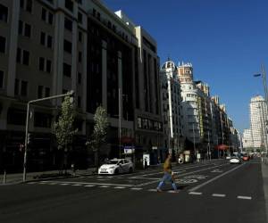 Un hombre cruza un paso de peatones en la avenida Gran Vía en el centro de Madrid, España, el sábado 14 de marzo de 2020. El primer ministro español, Pedro Sánchez, dijo que su gobierno declarará un estado de emergencia de dos semanas el sábado, otorgándose poderes extraordinarios que incluyen la movilización de las fuerzas armadas, para enfrentar el brote de COVID-19. Para algunos, especialmente los adultos mayores y las personas con problemas de salud existentes, puede causar enfermedades más graves, incluida la neumonía. (Foto AP / Manu Fernández)