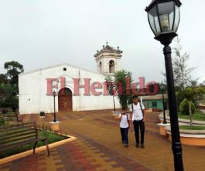 Dos estudiantes cruzan por la plaza central de Valladolid en el departamento de Lempira. Al fondo, la iglesia que data de mediados del siglo XIX. Fotos: Marvin Salgado / EL HERALDO.