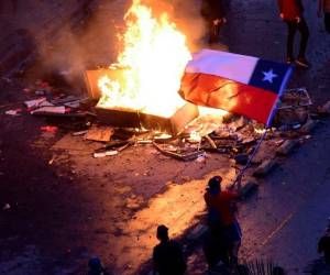 Riot police spray water to disperse demonstrators during a protest against Chilean President Sebastian Pinera's government in Santiago, on December 27, 2019. - Chile has been rocked by months of protests that began with strikes over metro fare hikes and quickly escalated into the most severe outbreak of social unrest since the end of the dictatorship of Augusto Pinochet nearly 30 years ago. (Photo by CLAUDIO REYES / AFP)