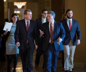 El senador Michael Bennet, D-Colo., Izquierda, y el senador Cory Gardner, republicano por Colorado, se dirigen a la cámara para una serie de votaciones procesales sobre un acuerdo bipartidista de inmigración, en el Capitolio de Washington.