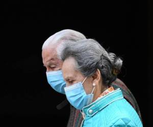 Madrid: Una pareja de ancianos con máscaras faciales camina en Madrid el 30 de abril de 2020 durante un encierro nacional para prevenir la propagación de la enfermedad COVID-19. España contó con otras 268 personas que murieron a causa del coronavirus, el número diario más bajo desde el 20 de marzo mientras el país se prepara para aliviar sus duras medidas de bloqueo. / AFP / Gabriel BOUYS