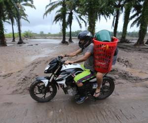 Los residentes salen de sus casas en los antiguos campos de plátanos del municipio de El Progreso, departamento de Yoro, Honduras.