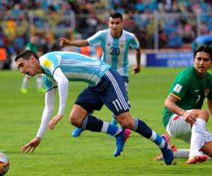 El argentino Angel Di Maria (L) compite por el balón con el delantero boliviano Juan Arce (R) durante su partido de la Copa Mundial de la FIFA 2018 en La Paz.