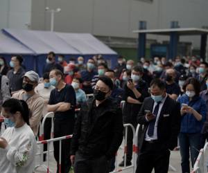 La gente espera en la cola para hacerse la prueba del coronavirus Covid-19 en un lugar de recogida de hisopos en Pekín el 25 de abril de 2022.