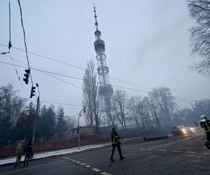 Un bombero corre después de que un ataque aéreo ruso golpeara la principal torre de televisión de Kiev.