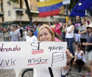 Los activistas de la oposición celebran fuera de las mesas electorales después de participar en una votación organizada por la oposición para medir el apoyo público al plan del presidente venezolano Nicolás Maduro de reescribir la constitución en Caracas. Fotos: AFP
