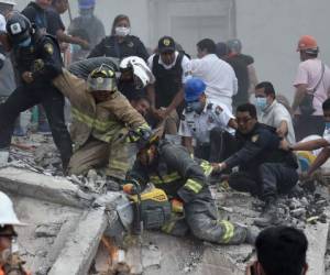 Salvadores, bomberos, policías, soldados y voluntarios desalojan desechos y escombros de un edificio aplanado en busca de sobrevivientes después de un poderoso terremoto en la Ciudad de México el 19 de septiembre de 2017.Un terremoto devastador en México mató el martes a más de 100 personas, según cifras oficiales, con 30 muertes preliminares registradas en la capital, donde los esfuerzos de rescate todavía estaban ocurriendo. / AFP PHOTO / YURI CORTEZ
