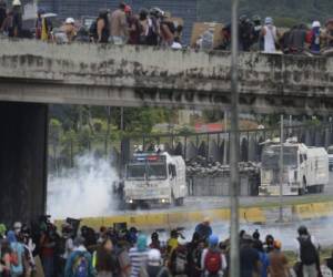 Opposition activists clash with riot police during a demonstration against the government of President Nicolas Maduro along the Francisco Fajardo highway in Caracas on June 19, 2017.Near-daily protests against President Nicolas Maduro began on April 1, with demonstrators demanding his removal and the holding of new elections. The demonstrations have often turned violent with 72 people killed and more than 1,000 injured so far, prosecutors say, and more than 3,000 arrested, according to the NGO Forum Penal. / AFP PHOTO / Federico PARRA