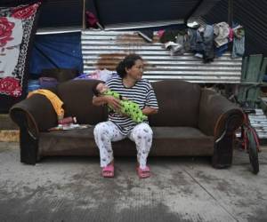 Una mujer sentada en un sofá frente a un refugio improvisado tras el paso del huracán Eta, luego degradado a tormenta tropical, en el municipio de La Lima, departamento de Cortés, Honduras.