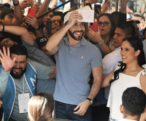 De gorra blanca, jeans y camisa celeste, color de su partido Nuevas Ideas, Bukele acudió a sufragar, junto a su esposa Gabriela Rodríguez, a las urnas instaladas en la avenida Olímpica, en el centro-oeste de San <b>Salvador</b>, en medio de una multitud de simpatizantes que lo aclamaban.