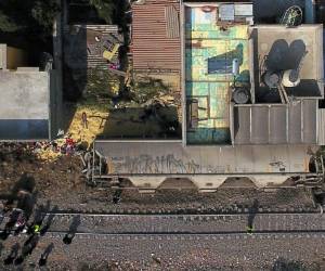 Vista aérea que muestra el sitio donde se descarriló el último vagón de carga y golpeó dos casas matando a cinco personas en el municipio de Ecatepec, justo al norte de la ciudad de México, el 18 de enero de 2018. Las víctimas murieron cuando fueron enterradas por el maíz. carro estaba llevando. / AFP / Pedro PARDO
