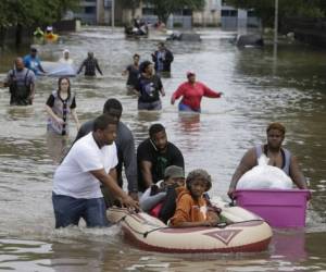 Con el agua hasta la cintura y cargando unas cuantas pertenencias, los habitantes de Houston salen de sus hogares para salvarse de las inundaciones, buscando refugio en otras zonas de la urbe, foto: AP.