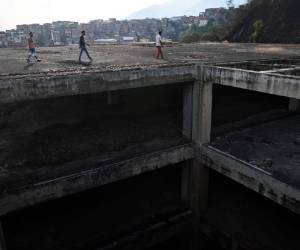 Una vista de como luce el edificio invadido Jehová Giré, no hay paredes externas, solo hay un baño y un balde plástico funciona como letrina, la electricidad se limita a la planta baja, y las plagas esparcen enfermedades. Foto: AFP.