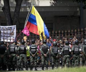 Government supporters march in Caracas, Venezuela, Monday, Sept. 11, 2017. Government supporters blamed opposition lawmakers for United States' sanctions against Venezuela and asked the Attorney General to prosecute them. (AP Photo/Ariana Cubillos)