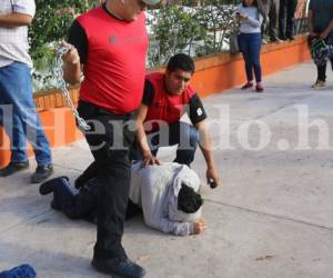 Uno de los estudiantes es sometido por un miembro de seguridad privada que tiene una cadena en mano. Foto Estalin Irías/ EL HERALDO.