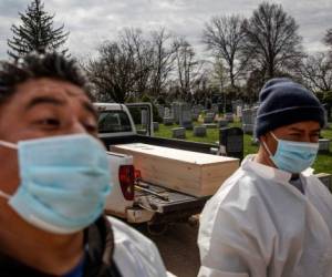 El ataúd de una persona que se supone que murió de coronavirus está por ser enterrado, sin la presencia de familiares, en el cementerio Mount Richmond de la Hebrew Free Burial Association, en el distrito neoyorquino de Staten Island, el martes de abril de 2020. (AP Foto/David Goldman)