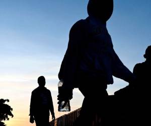 Palenque, Chiapas, México: los migrantes caminan cerca de un tren conocido como 'La Bestia' en Palenque, estado de Chiapas, México, el 25 de julio de 2019. El cruce ilegal de hondureños, salvadoreños y guatemaltecos a México aumentó significativamente desde octubre, pero migratorio Los controles han pospuesto el 'sueño americano' de las familias migrantes. / AFP / ALFREDO ESTRELLA