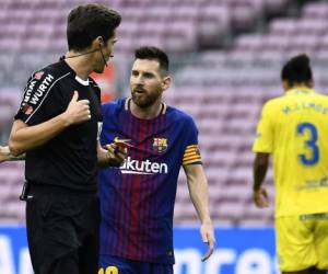 El delantero argentino Lionel Messi (R) discute con el árbitro Jose Luis Munuera Montero durante el partido de fútbol de la liga española FC Barcelona vs UD Las Palmas en el estadio Camp Nou de Barcelona el 1 de octubre de 2017. / AFP / JOSE JORDAN
