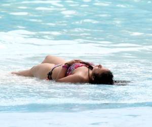 Sumergida en la piscina o mar, disfruta de los rayos del sol.