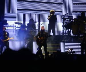 Fonseca interpretando el primer tema de la noche acompañado de su guitarra y su banda.