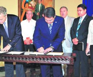 Terry García de National Geographic y el presidente Juan Orlando Hernández en la firma del acuerdo.