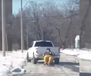 La mujer era remolcada por una camioneta blanca en medio de la nieve.