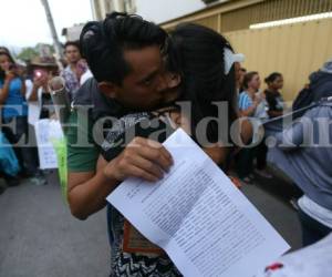 Uno de los estudiantes de la UNAH acusados se funde en un abrazo al salir de los juzgados mientras sosteniene el acta de notificación de medidas sustitutivas, foto: Alejandro Amador / EL HERALDO.