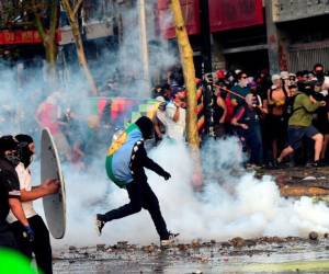 Santiago: TOPSHOT - Los manifestantes se enfrentan con la policía antidisturbios durante una protesta contra el gobierno y para conmemorar el primer aniversario de la muerte del líder indígena mapuche Camilo Castrillanca, asesinado en una operación policial, en Santiago, el 14 de noviembre de 2019. Los manifestantes están exigiendo Una mayor reforma social del presidente Sebastián Piñera, quien ha anunciado varias medidas en un intento por apaciguar a los manifestantes, incluida una promesa de cambiar la constitución que data de la dictadura de Augusto Pinochet de 1973-90. / AFP / Martin BERNETTI