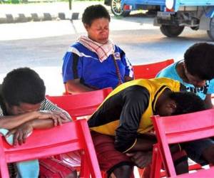 Esta fotografía muestra a entristecidos parientes de los pasajeros del desaparecido vuelo de la aerolínea Trigana en el aeropuerto de Sentani en Jayapura, en la provincia de Papúa, Indonesia, el lunes 17 de agosto de 2015.