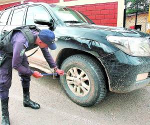 Un agente de la Policía muestra las manchas de supuesta sangre en la llanta de la camioneta abandonada en Loarque.