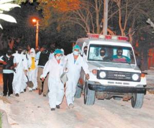 Personal de la ATIC y de Medicina Forense al momento de salir de las instalaciones de Renaciendo con los dos cadáveres.