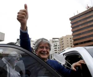 El candidato presidencial Guillermo Lasso, abanderado del partido Creando Oportunidades o CREO, levanta el pulgar después de asistir a un evento con su rival Yaku Pérez. FOTO: AP