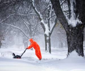 Un hombre quita la nieve del camino en Janesville, Wisconsin. (Fotos: AP)