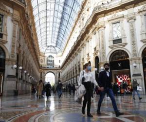 Unas personas usando cubrebocas caminan por el centro de Milán, Italia, el 17 de octubre de 2020. Foto: AP