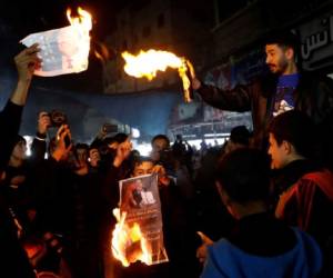 Manifestantes queman imágenes del presidente estadounidense Donald Trump durante una protesta contra el plan para la paz de Medio Oriente, en el campo de refugiados de Jabaliya, en la Franja de Gaza, el martes 28 de enero de 2020. (AP Foto/Adel Hana)