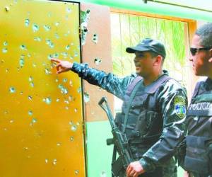 Un policía muestra decenas de impactos de bala producto del enfrentamiento de tres horas la noche del sábado.