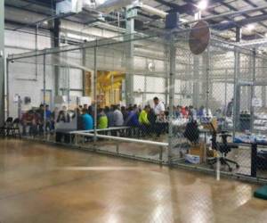 En esta fotografía proporcionada por la Oficina de Aduanas y Protección Fronteriza de Estados Unidos, personas que han sido detenidas por intentar entrar al país sin autorización, están sentadas en una de las jaulas en el centro de McAllen, Texas, el domingo 17 de junio de 2018.